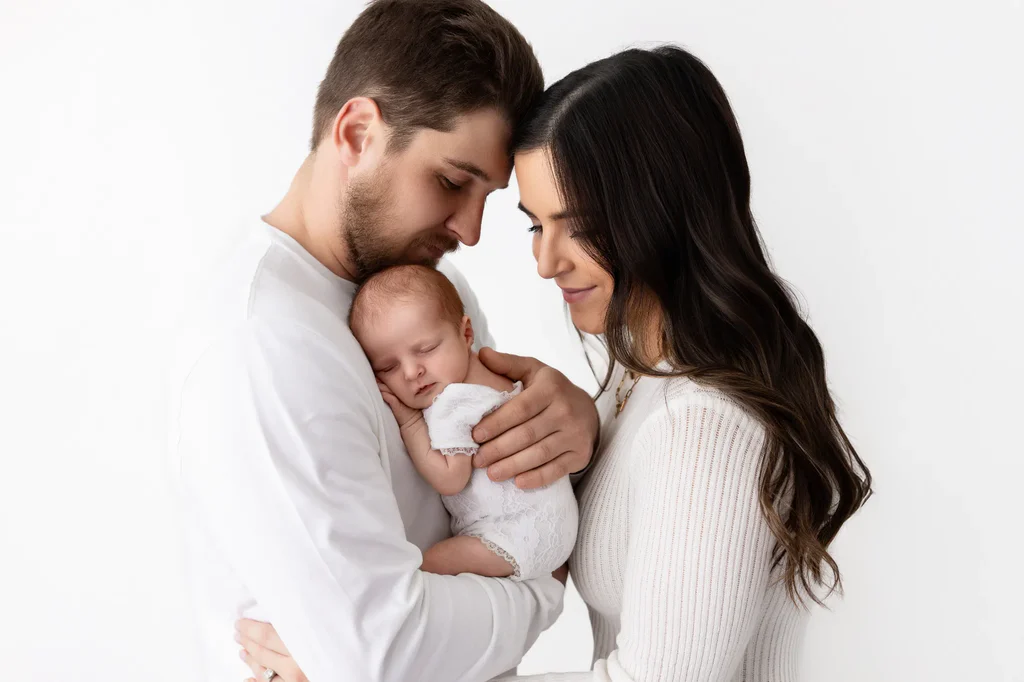 Mom and dad holding their newborn baby during a newborn photography session at Yulia Moore Photography in East Tennessee
